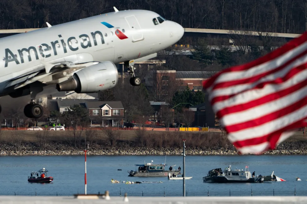 An American Airlines plane taking off from Reagan National Airport in front of wreckage from a crash involving an American Eagle plane and helicopter over the Potomac River on January 29, 2025. | Source: Getty Images 